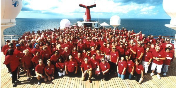 group of nearly 400 people gathered on the Conquest’s Sky Deck for a group picture.